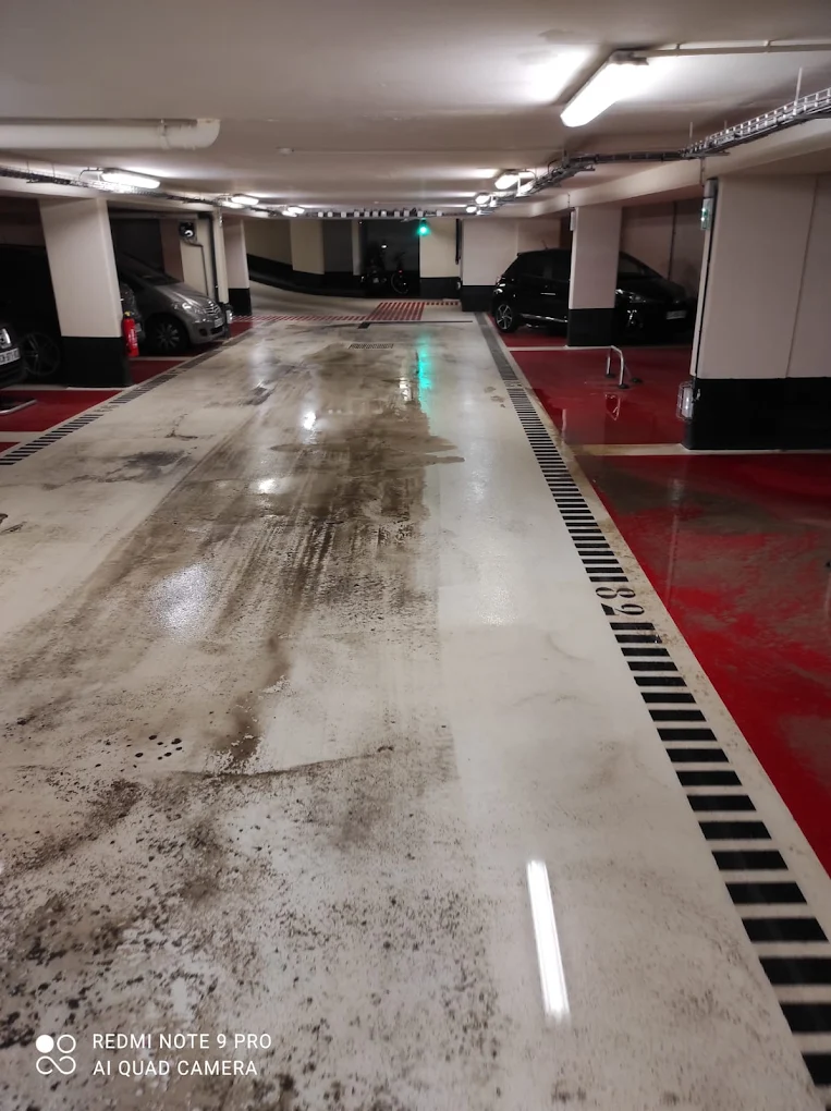 Parking souterrain présentant des traces de circulation, des salissures et des dépôts avant une intervention de nettoyage réalisée par MJ Nettoyage.