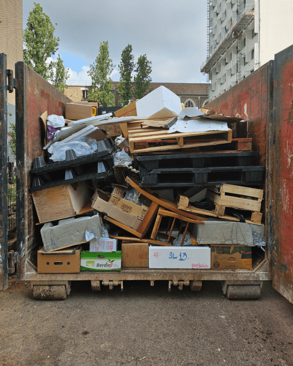 Benne contenant des cartons et des déchets issus d'une opération de débarras professionnel.