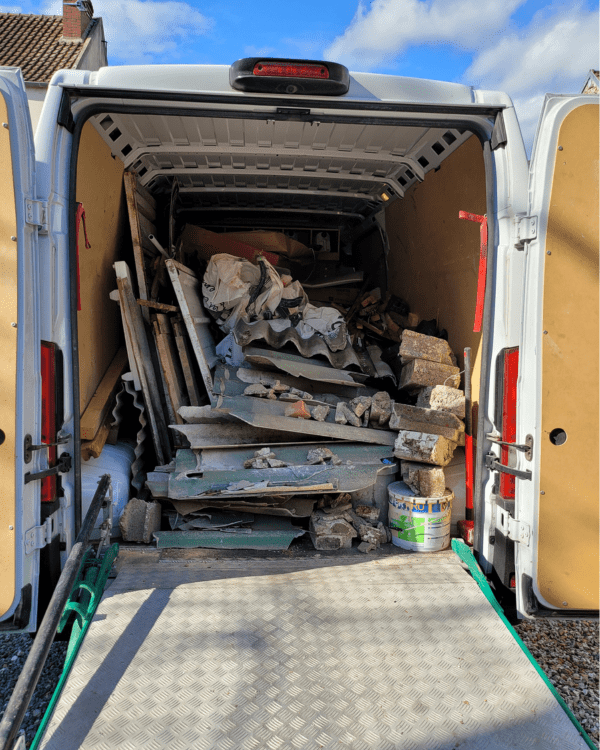 Camionnette utilitaire remplie de gravats et de matériaux issus d'une opération de débarras.