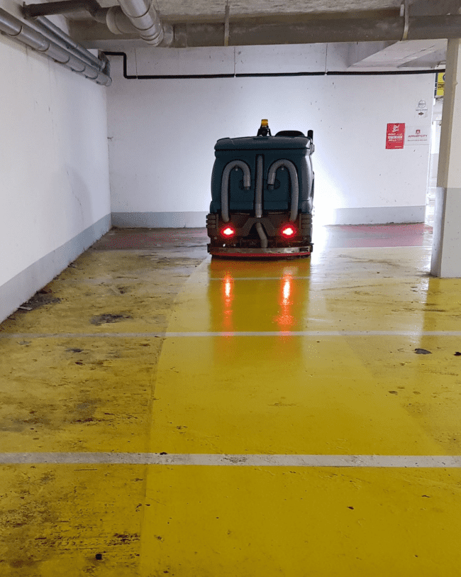 Autolaveuse professionnelle en cours d'intervention lors du nettoyage d'un parking en Île-de-France.